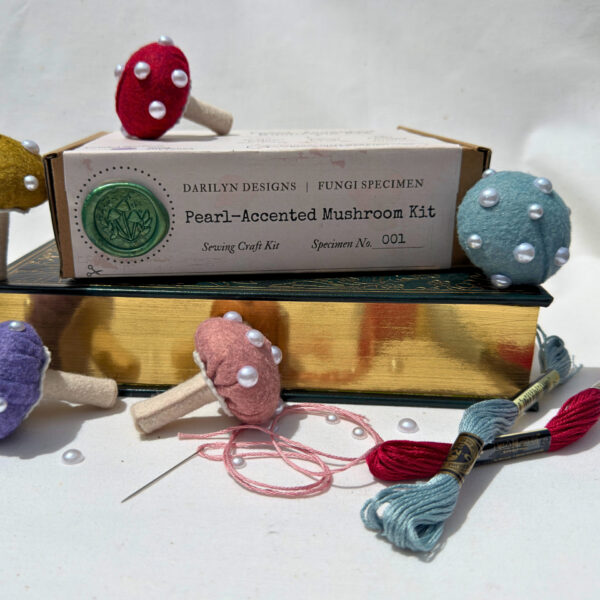 Pearl-accented mushroom kit surrounded by completed mushrooms and loose supplies.