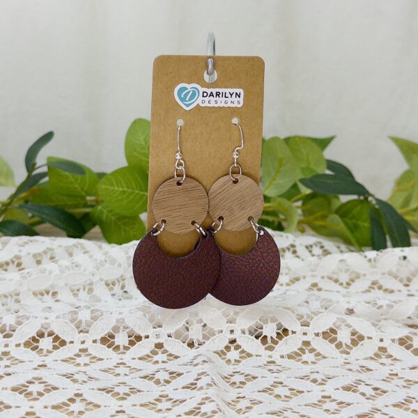 Walnut and faux leather geometric earrings hanging on a stand.