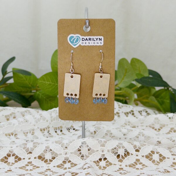 Pair of rectangular birch earrings with silver detailing and a blue bead fringe.
