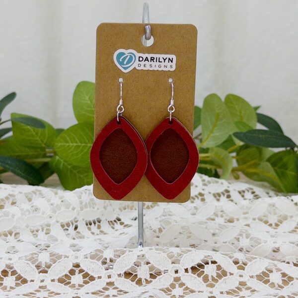 Dark brown and crimson faux suede layered earrings hanging on a stand.