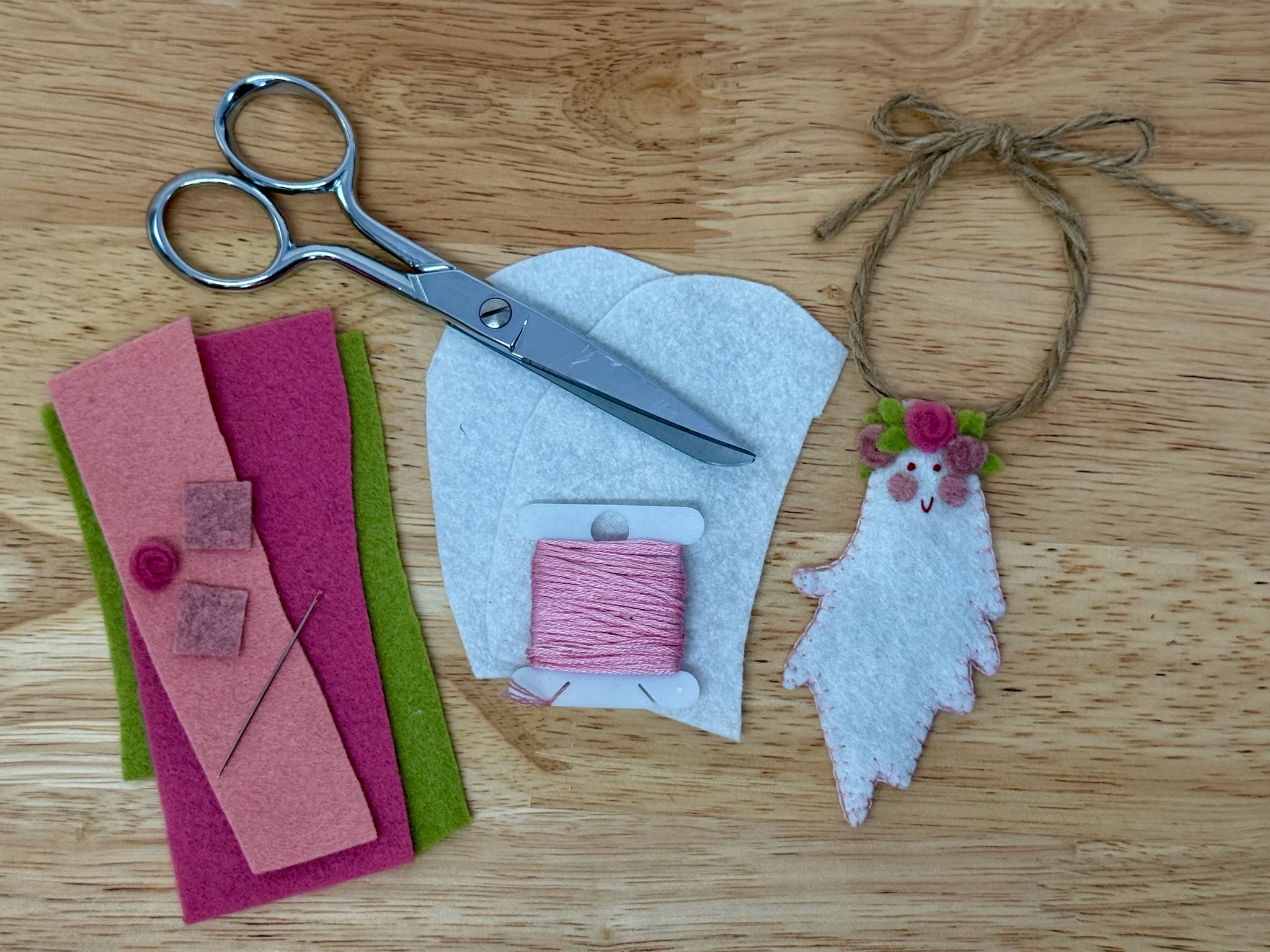 Materials for the Boo-quet felt ghost pattern: felt scraps, embroidery floss, scissors, needle, twine, and a finished ghost ornament