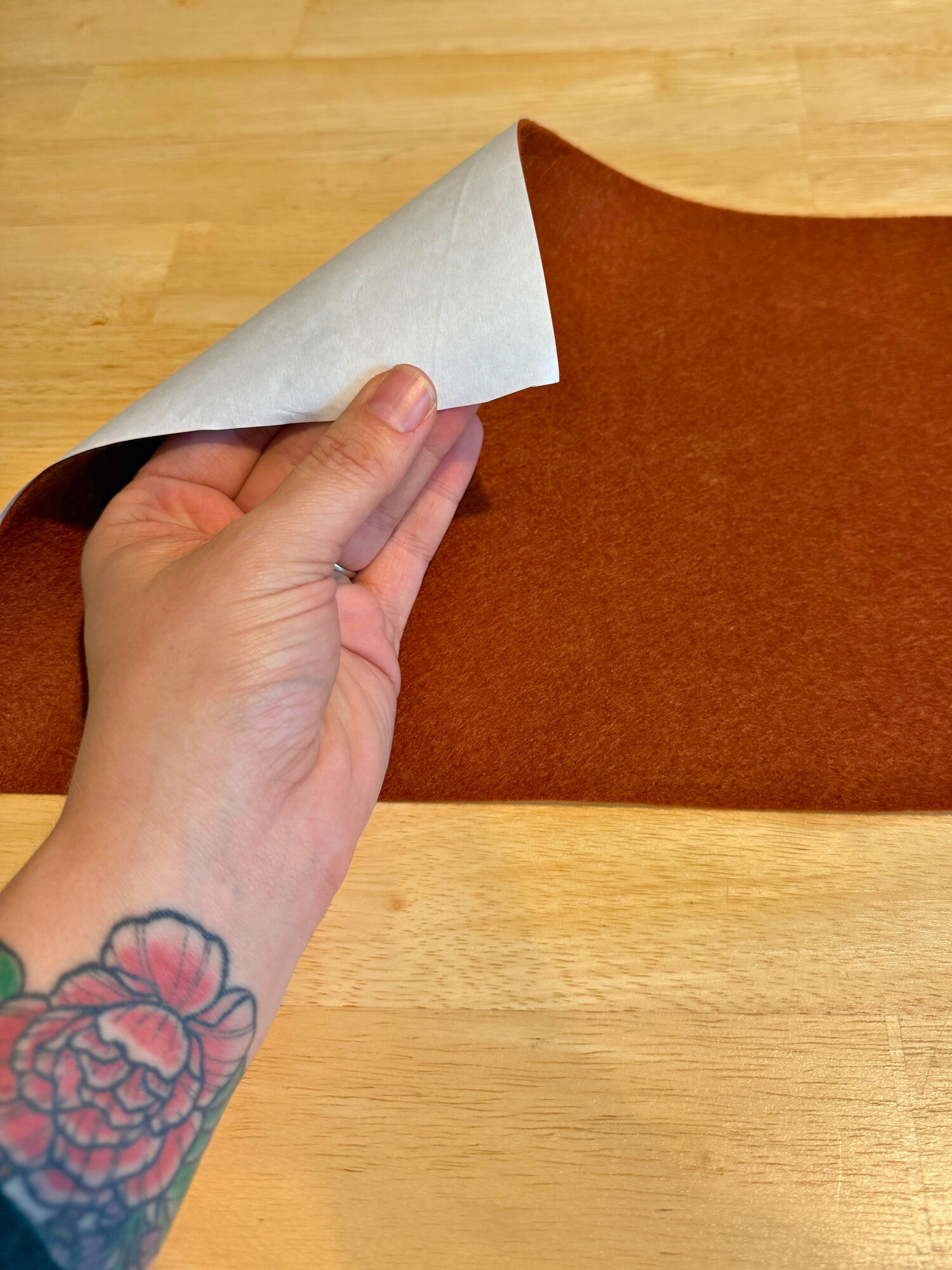 Freezer paper ironed to the back of a sheet of rust felt, corner peeled up