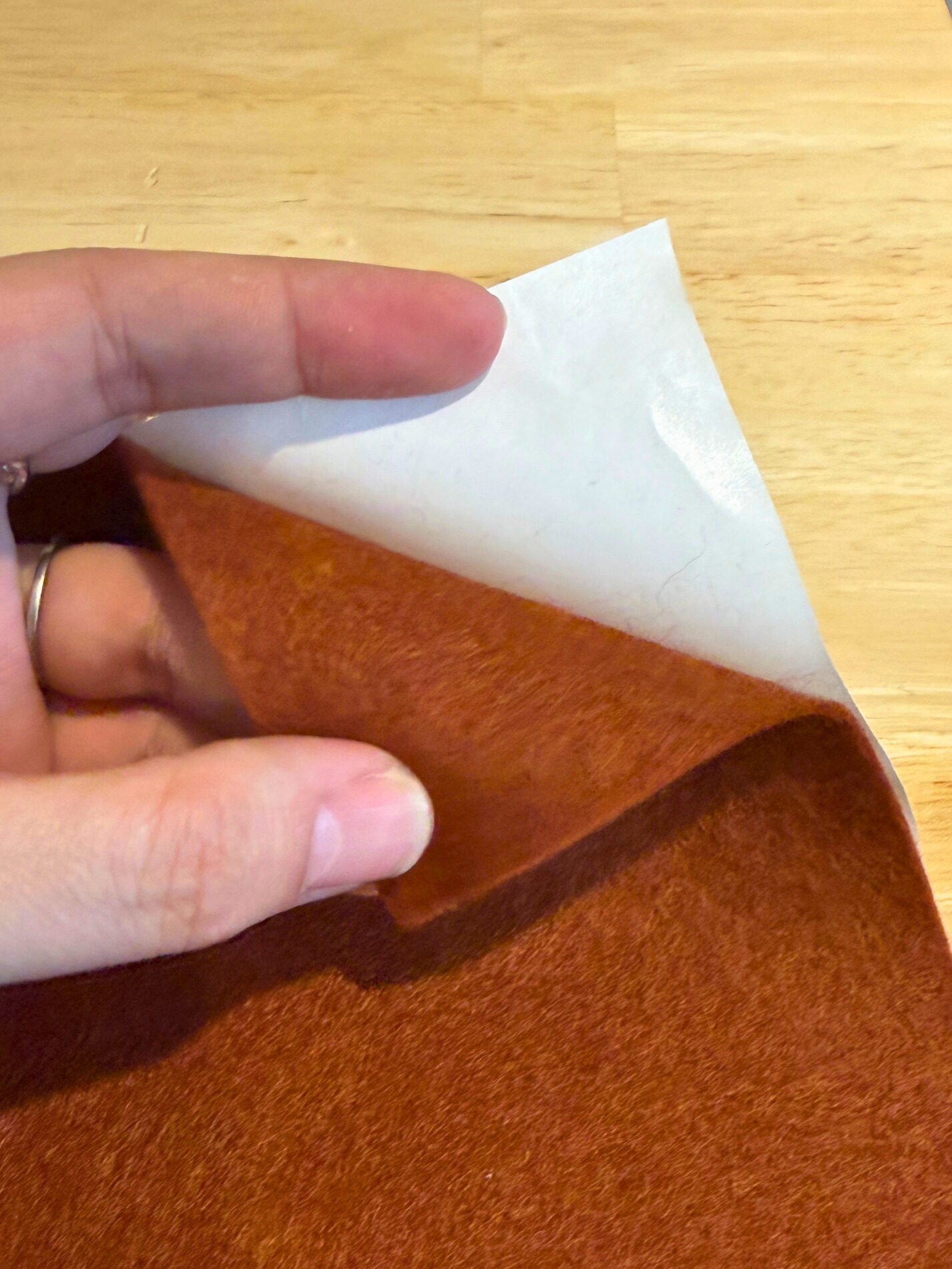 Peeling freezer paper cleanly off the back of cut felt