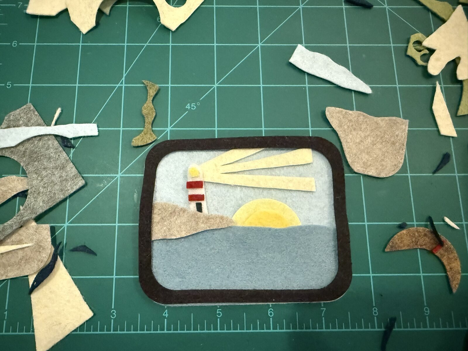 An early draft: a felt lighthouse over a soft blue sea
