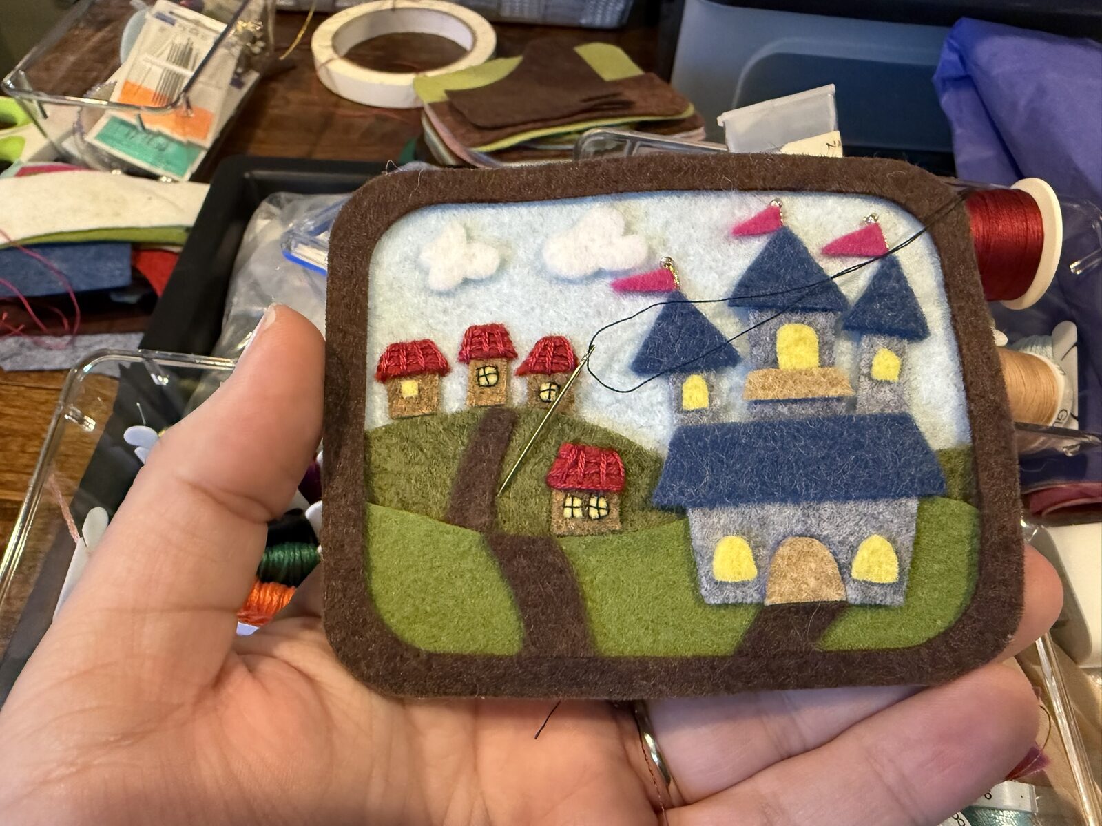 Hand-embroidering details into the felt castle scene