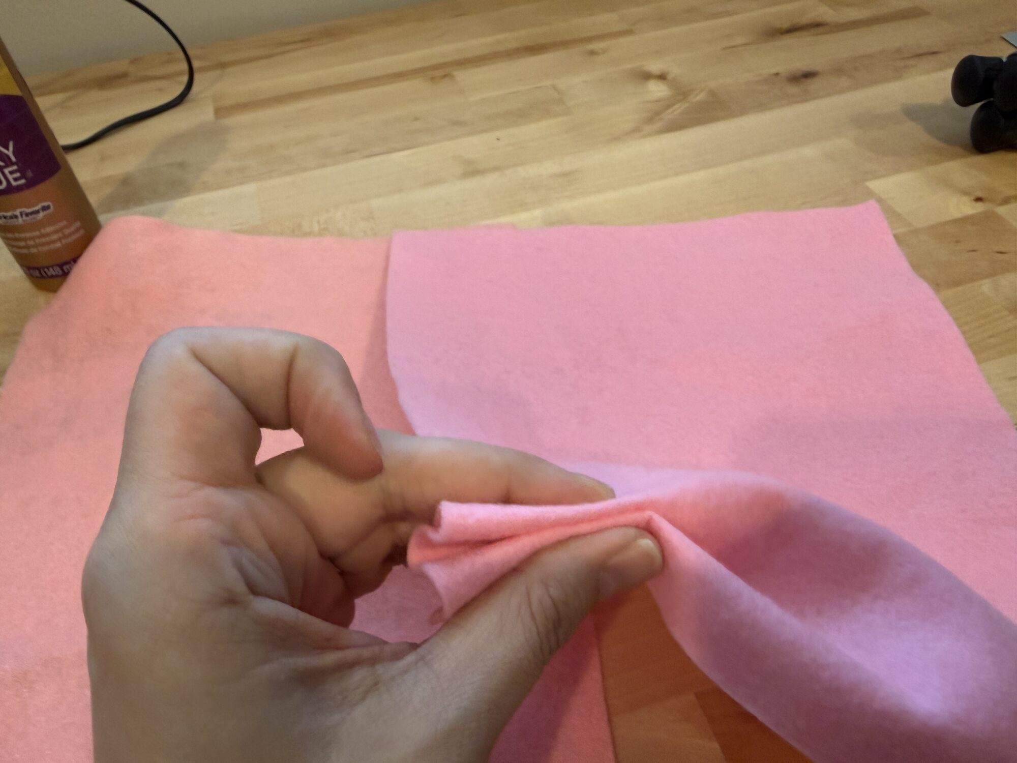 Squeezing a sheet of wool-blend felt between fingers for the squish test
