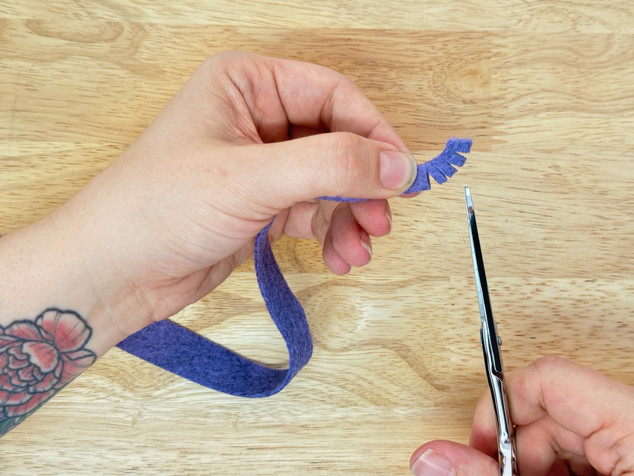 Cutting fringe into the folded felt strip