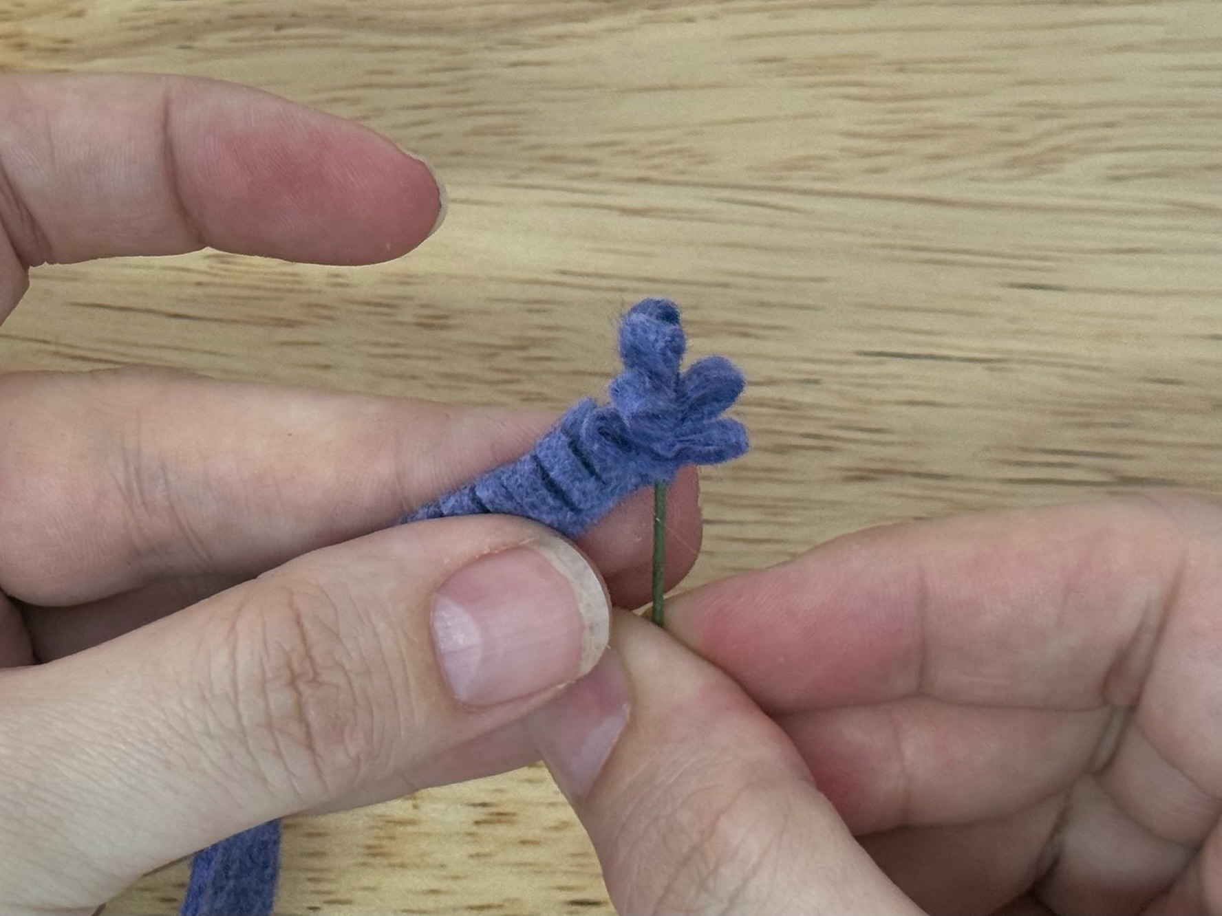 A finished felt lavender bloom, spiral-wrapped on its wire stem